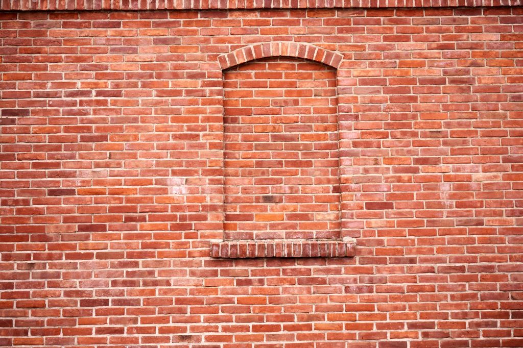 A brick wall with bricked window