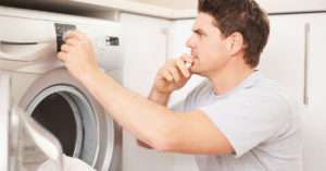 Man looking at washing machine settings