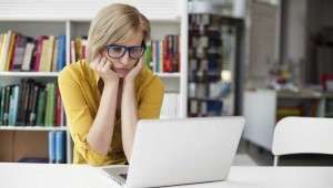 woman worriedly staring at her laptop