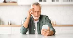 Concerned older man looking at his phone