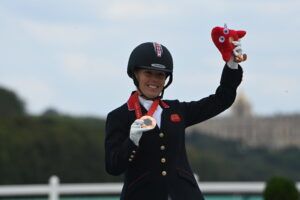 Sophie Wells celebrates on the Paralymppics podium with her bronze individual medal.