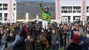 Jockey Mark Walsh salutes the crowd as Inothewayurthinkin enters the winners enclosure after winning The Boodles Cheltenham Gold Cup 2025 at the Cheltenham Festival