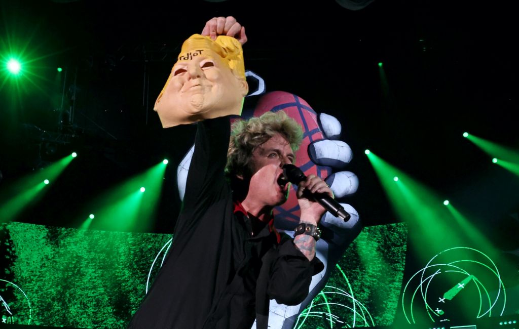 Green Day's Billie Joe Armstrong holds a Donald Trump mask while performing onstage