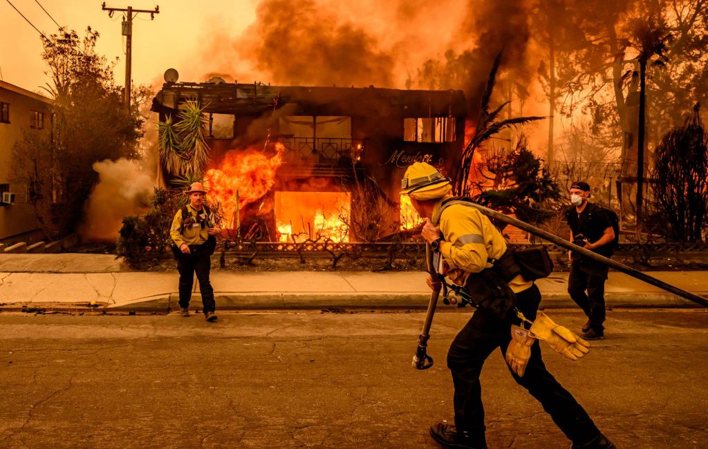 Firefighters work the scene as an apartment building burns during the Eaton fire in the Altadena area of Los Angeles county, California on January 8, 2025. (Photo by JOSH EDELSON/AFP via Getty Images)