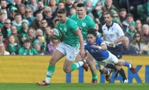 Ireland's Jack Crowley runs clear of Ange Capuozzo's tackle during the 2024 Six Nations match against Italy.