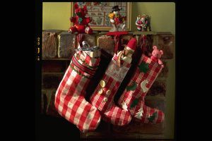 Three gingham stockings hanging by the fire