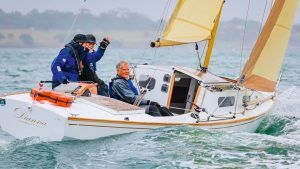 The modified cruising Diamond Dianna sailing on slightly choppy seas. There are three people looking happy in the boat.