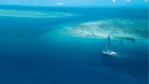 An aerial shot of a yacht in a tropical sea