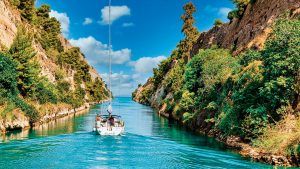 Canal with boat sailing down it and cliffs on either side