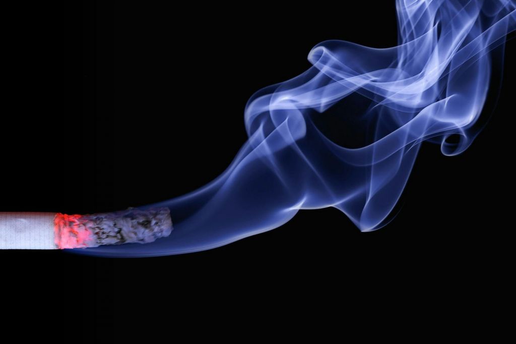 A lit cigarette against a black background.