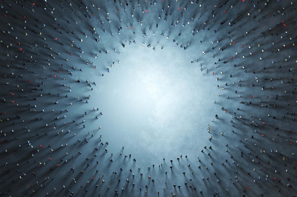 A photo illustration of a large group of people seen from above, spaced around a large open circle