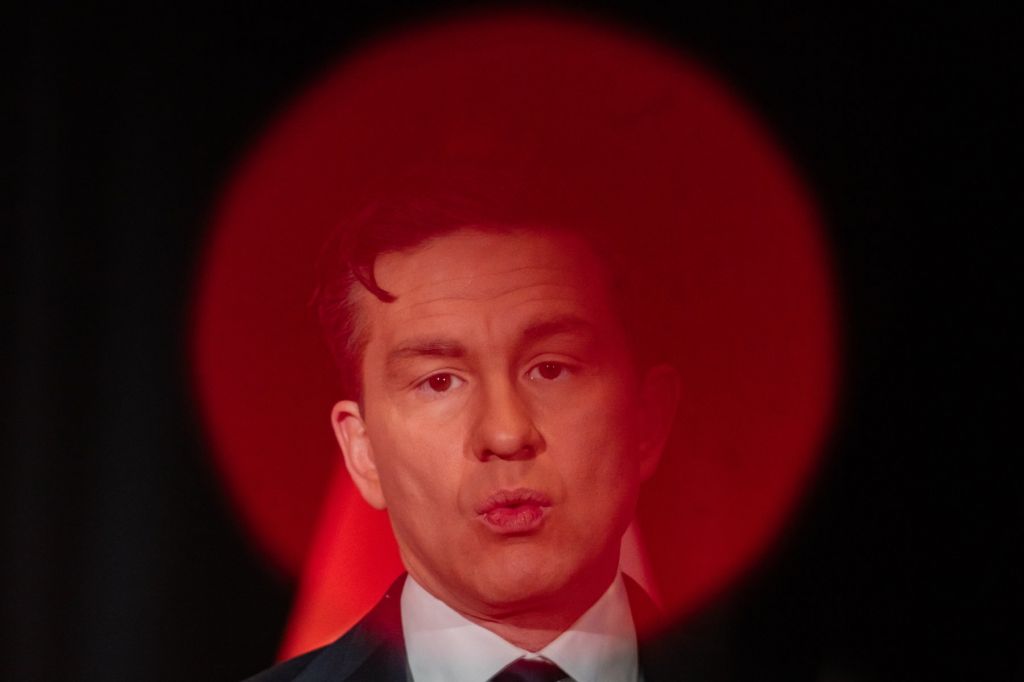 A photo of Pierre Poilievre with a red circle of light spotlighting his face