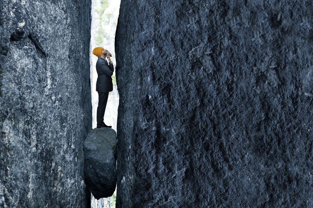 A photo illustration shows Jagmeet Singh standing on a small rock and stuck between two giant rocks