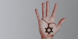 A hand holding a Star of David.