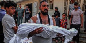 A Palestinian man carrying the body of a child in Gaza in October of 2023.