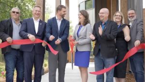 Premier Danielle Smith cuts the ribbon with a giant pair of scissors at the “Lakeview Recovery Community” west of Edmonton.