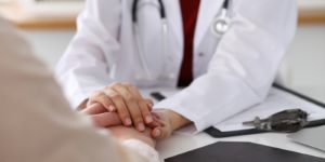 A doctor holding the hand of a patient.