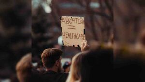 A person holding a sign that reads abortion = healthcare.