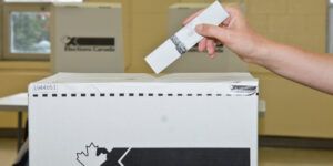 A ballot going into a box.