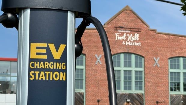 EV charger outside a brick building with sign that reads 'Food hall and market'