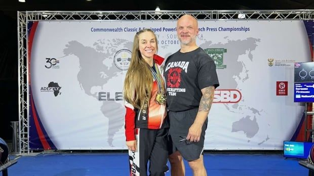 Husband and wife stand on number one podium in sportswear. 