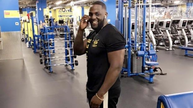 A man poses for a photo in a gym