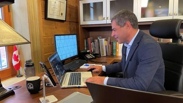 Alain Rayes at his computer in his office.