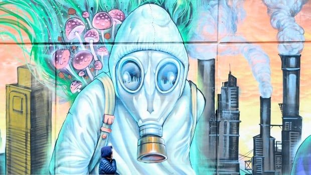 A person walks past a climate change themed nature mural on Earth Day during the COVID-19 pandemic in Toronto on Thursday, April 22, 2021. 