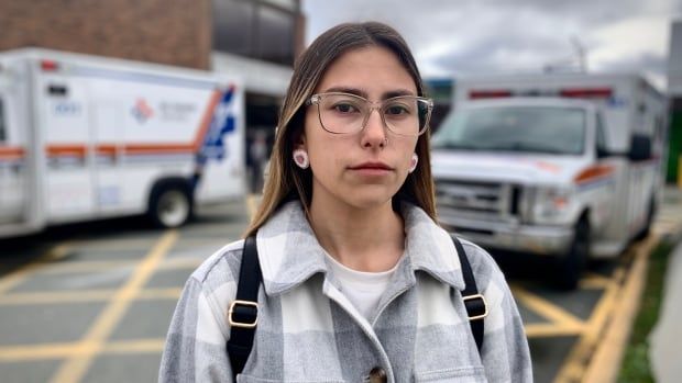 A woman outside a hospital with serious expression