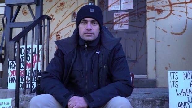 Dr. Tarek Loubani sits in front of London MP Peter Fragiskatos's office after telling CBC News he was responsible for covering it in ketchup just hours after his charges for the same offence were dropped.