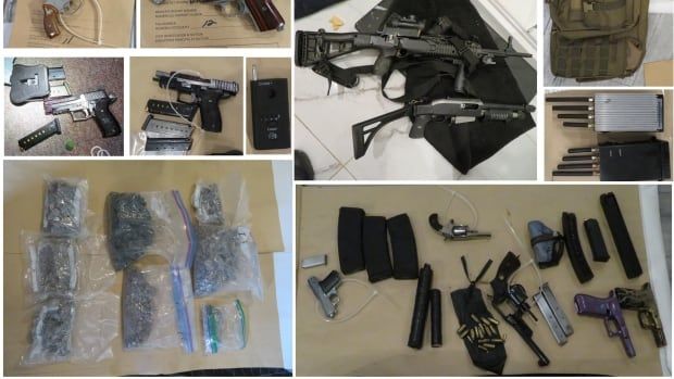 Weapons and drugs in baggies on display on a table.