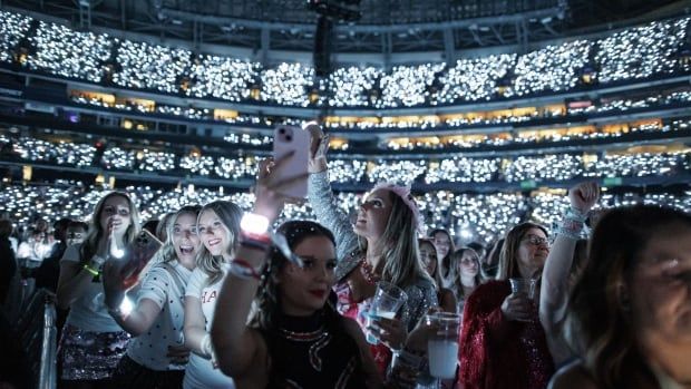 Happy fans in the audience taking selfies and listening to Taylor Swift at the first of six sold-out concert shows in Toronto.