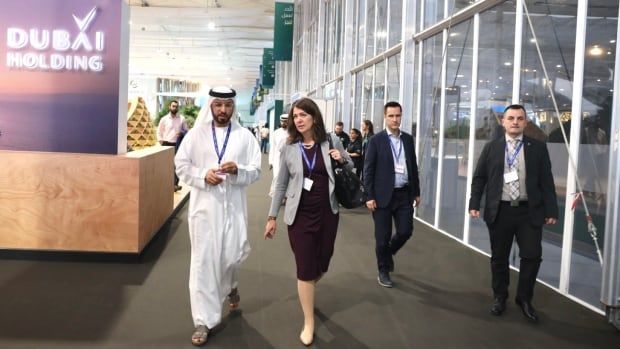 A man and a woman walk down a hallway.