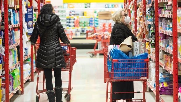 Two people shop in a grocery store.