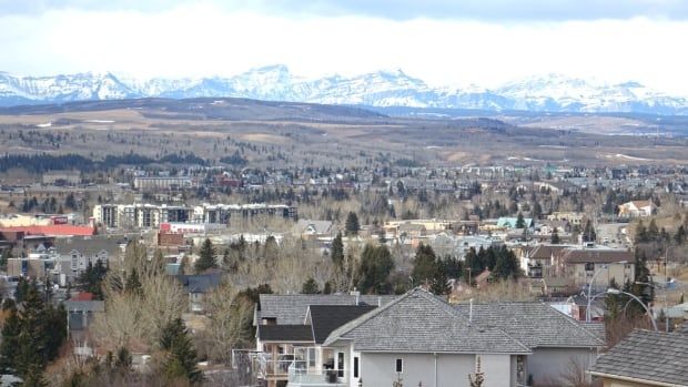 An overview of residential communities with the snow-capped Rocky Mountains in the distance. 