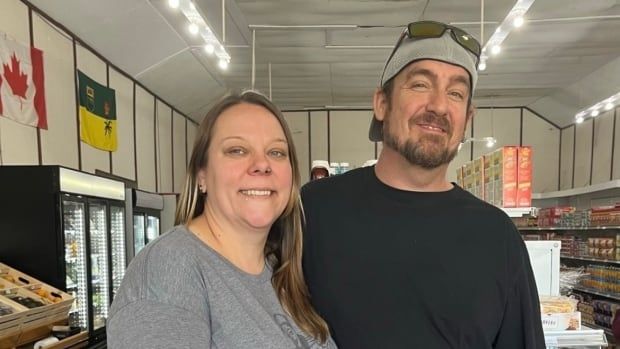 Woman and man stand in a grocery store. 