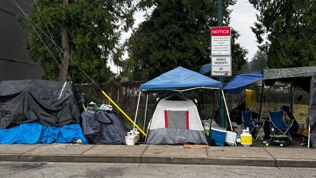 Tents erected along a sidewalk.