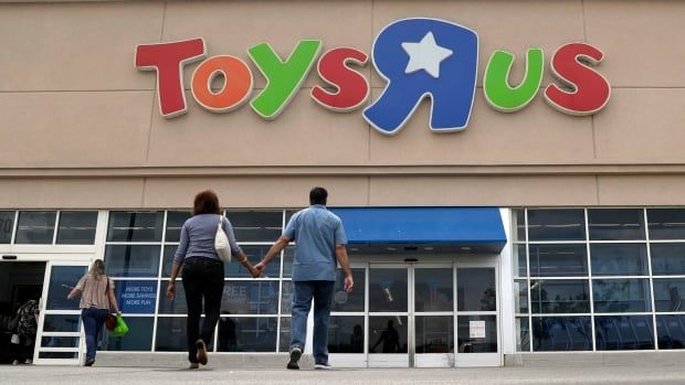 Shoppers walk into a Toys "R" Us store.