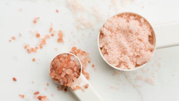 Pink salt is seen in spoons.