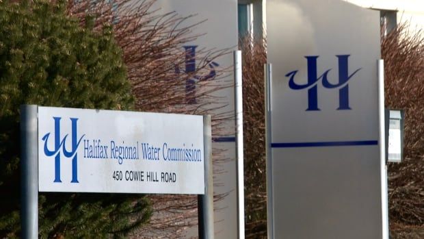 A sign that reads Halifax Regional Water Comission in front of a green bush.