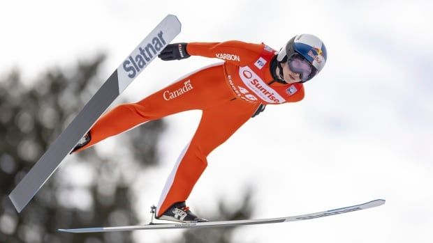 A female ski jumper competes.