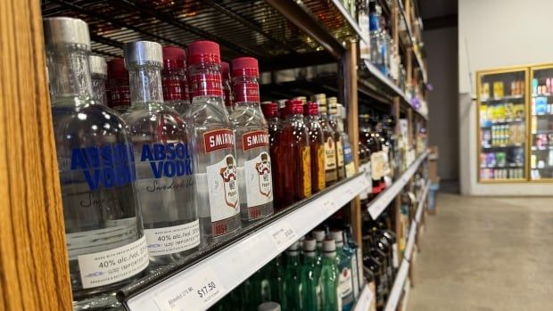 A view of liquor bottles on a store shelf, with vodka in the foreground.