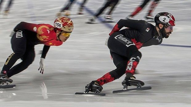 Canadian speed skater Steven Dubois is chased by Liu Guanyi of China during the men's 5,000-metre relay final at the ISU world short track championships in Beijing on March 16, 2025. 