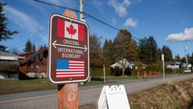 A sign near the road marking the border between the U.S. and Canada.