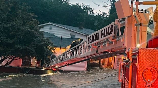 Rescuers save people from an inn during extreme flooding.