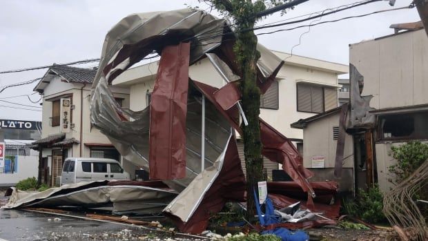 A heavily damaged building with debris surrounding it.