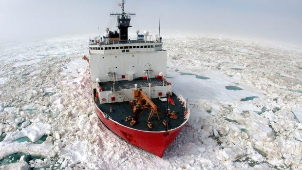 A ship breaks through icy water.