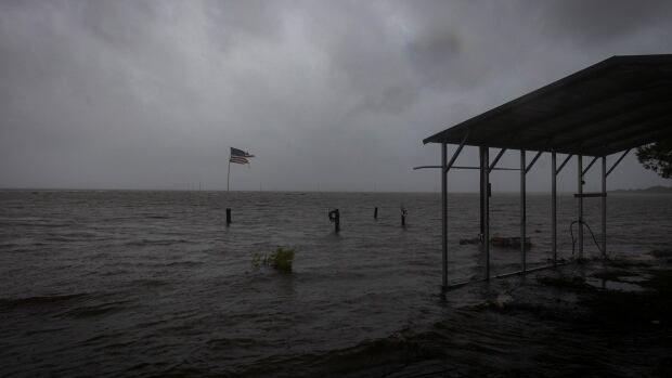 A tattered U.S. flag waves in the wind in Eastpoint, Fla., ahead of the expected landfall of Hurricane Helene.