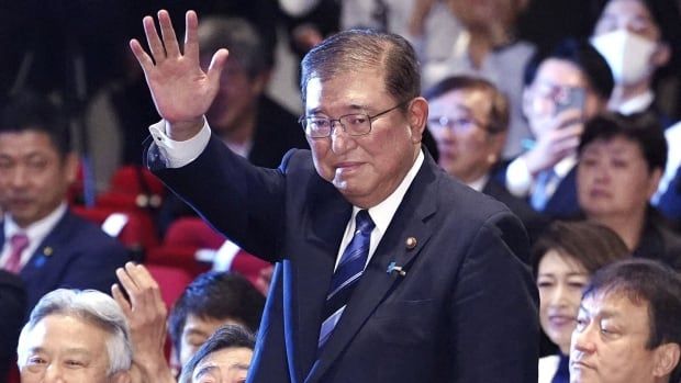 Former Japanese defence minister Shigeru Ishiba waves.