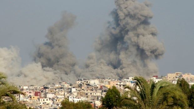 Black smoke billows above a city following an airstrike.